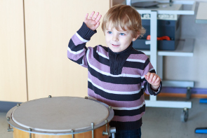 A boy playing the drum showing a child's development.